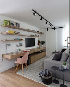 a living room filled with furniture and a flat screen tv on top of a wooden shelf