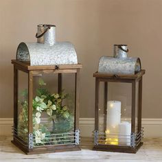 two metal lanterns with candles and flowers in them