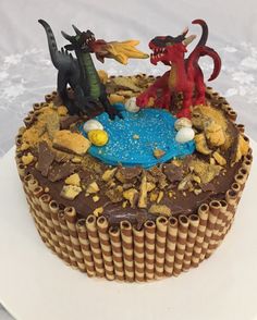 a cake decorated with chocolate frosting and plastic dragon figurines sitting on top of it