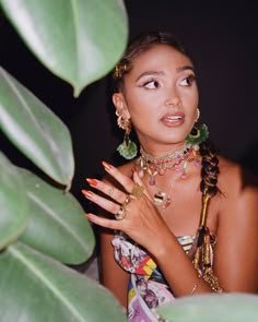 a young woman with her hands on her chest, wearing jewelry and looking at the camera