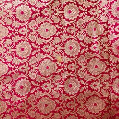 red and gold brocaded fabric with large flowers on it's side, close up