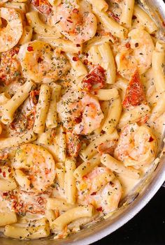 a pan filled with pasta covered in shrimp and sauce