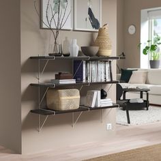 a living room filled with furniture next to a wall mounted book shelf covered in books