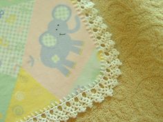 a baby blanket with an elephant and giraffe design on the bottom, along with crocheted edges