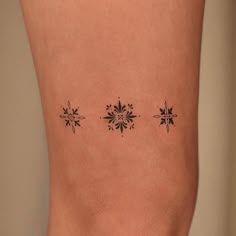 a woman's leg with three small snowflakes on the back of her thigh