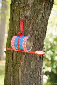 a red and blue tin can hanging from a tree