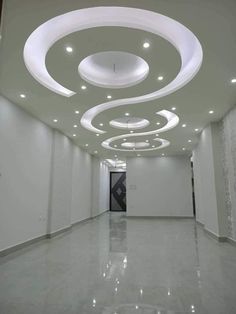 an empty room with white walls and circular lights on the ceiling is lit by recessed lighting