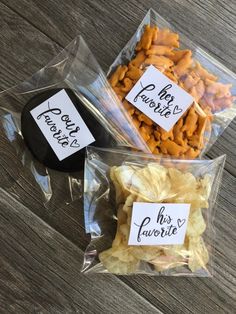 three plastic bags filled with different types of snacks on top of a wooden table next to each other