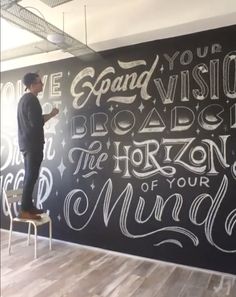 a man standing in front of a blackboard with writing on it