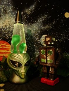 two alien figurines sitting next to each other in front of a space scene