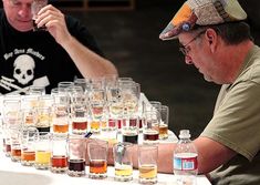 two men sitting at a table filled with glasses