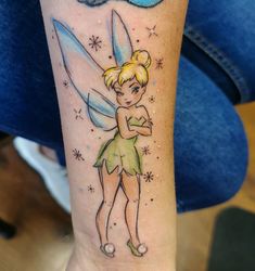 a woman with a tattoo on her arm that has a tinkerbell on it