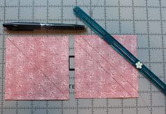 a piece of pink fabric next to a black pen on top of a cutting mat