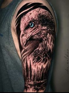 an eagle with blue eyes and trees on his arm is shown in this tattoo design