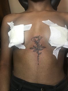 a woman has torn up pieces of paper on her back and is holding a rose tattoo