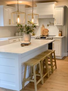 a kitchen island with stools next to it and a potted plant on top