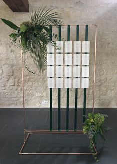 a potted plant sitting on top of a metal stand in front of a wall