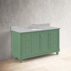 a green bathroom vanity with marble top and two faucets on the sink area