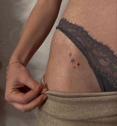 a woman's stomach with small tattoos on her belly and the bottom part of her panties