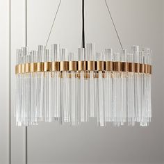 a chandelier with clear glass tubes hanging from it's gold trimmings