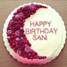 a birthday cake decorated with flowers and the words happy birthday sani written on it