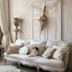 a living room filled with white furniture and pillows