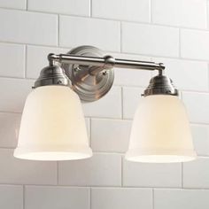 two light bathroom fixture with white glass shades on the top and bottom, in an old - fashioned look