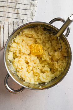 a pot filled with food sitting on top of a white countertop next to a towel