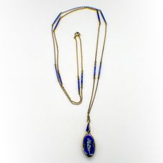 "Antique gilt 935 sterling silver long chain necklace, decorated with blue & black enamel bar links, and holding oval form miniature watch pendant, also decorated with blue and black enamel and featuring depiction of a cupid playing the flute. The watch has wind-up mechanism, runs. This stunning necklace measures: the chain is 32\" long, the watch is 1\" tall and 5/16\" wide, weighing a total 18.8 grams. EA2587" Oval Enamel Locket Jewelry, Oval Locket Necklace In Enamel, Oval Enamel Locket Necklace, Blue Enamel Locket Jewelry, Blue Jewelry With Black Enamel For Formal Occasions, Oval Engraved Enamel Necklace, Enamel Hallmarked Oval Pendant Necklace, Blue Oval Link Necklaces For Gift, Blue Oval Link Necklace For Gift