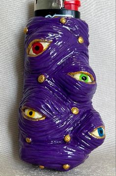 a purple bottle with eyes and gold rivets on it