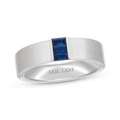 a white gold ring with a blue stone in the center and an inscription on it