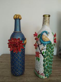 two colorful vases sitting on top of a wooden table next to each other,