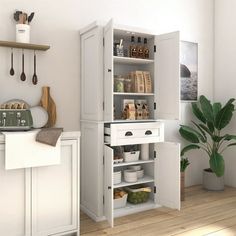 a kitchen with white cabinets and wooden floors