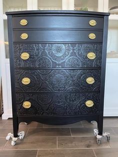 an ornate black chest of drawers with gold knobs on the top and bottom drawer