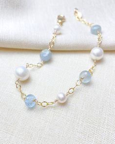 This piece was a commission for a bride to wear on her wedding day as "something blue." I loved it so much that I made more. Sea green aquamarine beads make a soothing and coastal chic style paired with white freshwater pearls. The aquamarine gems and pearls are stationed on a dapped open link chain that gives the piece a light and airy look. Bracelet length: 7 inches plus a 1-inch extender Materials: aquamarine, cultured freshwater pearls, gold fill Elegant Light Blue Pearl Jewelry, Elegant Blue Pearl Bracelet With Charm, Elegant Blue Aquamarine Bracelets, Elegant Blue Beaded Bracelet With Pearl Charm, Elegant Blue Beaded Bracelets With Pearl Charm, Elegant Light Blue Aquamarine Bracelet, Elegant Aquamarine Beaded Bracelets, Elegant Turquoise Aquamarine Beaded Bracelets, Blue Pearl Chain Jewelry For Wedding