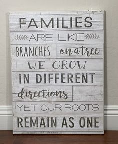 a wooden sign that says families are like branches on tree, we grow in different directions yet our roots remain as one