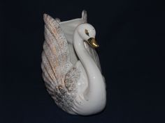 a white ceramic swan figurine on a black background