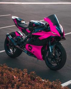 a pink motorcycle parked in a parking lot