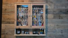 a wooden wall with two glass doors and shelves filled with different types of fishing equipment