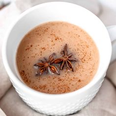 an overhead view of a cup of hot chocolate with cinnamon and star anise on top