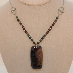 Made with love, this necklace features a stunning Stick Agate pendant stone flanked by Bronzite, Biotite, Mahogany Jasper, Smokey Quartz, and Hill Tribe Silver. At 22 3/4" long, this piece is sure to make a statement! Check out the coordinating earrings. Elegant Brown Jewelry With Stones, Brown Jasper Spiritual Jewelry, Brown Natural Stone Jewelry For Gifts, Elegant Jewelry With Rectangular Pendant And Natural Stones, Brown Natural Stone Jewelry As A Gift, Brown Jewelry With Natural Stones As Gift, Brown Natural Stone Jewelry Gift, Bohemian Jewelry With Rectangular Natural Stone Pendant, Bohemian Jewelry With Rectangular Gemstone Pendant