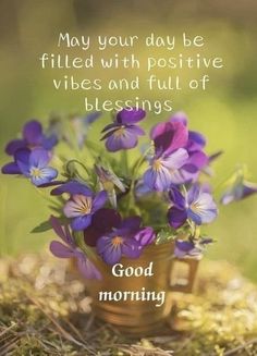 purple flowers are in a small vase on the ground with a quote about good morning