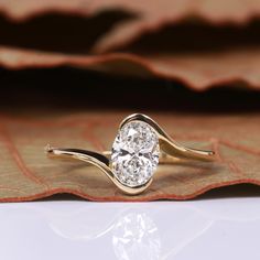 a diamond ring sitting on top of a leaf