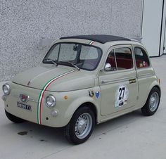 an old style car is parked in front of a building with numbers painted on it