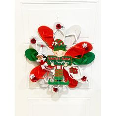 an ornament hanging on the front door with santa's helpers and snowflakes