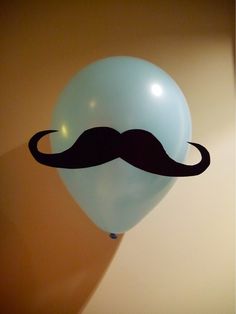 a blue balloon with a black mustache on it's side, hanging from the ceiling