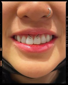 a close up of a person's teeth with piercings