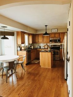 an open kitchen and dining room with wood flooring