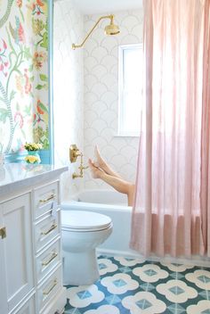 a woman is sitting in the bathtub with her feet up on the shower curtain