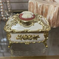 a white and gold jewelry box sitting on top of a table